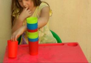 child reaching across midline to reach for a cup